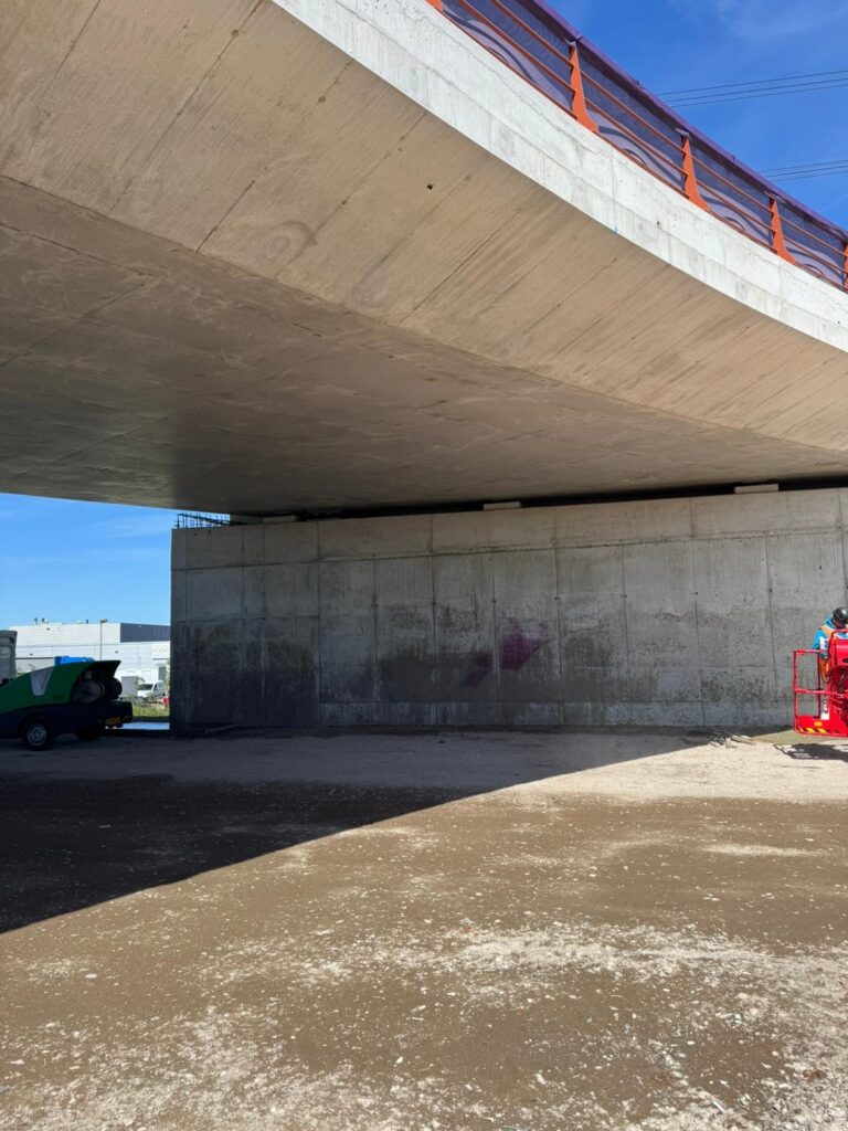 Na het verwijderen van graffiti op betonnenwand